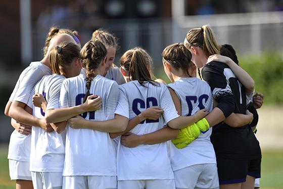 图为英国波胆网站女子足球队在一场比赛中身穿白色和紫色制服挤在一起. 
