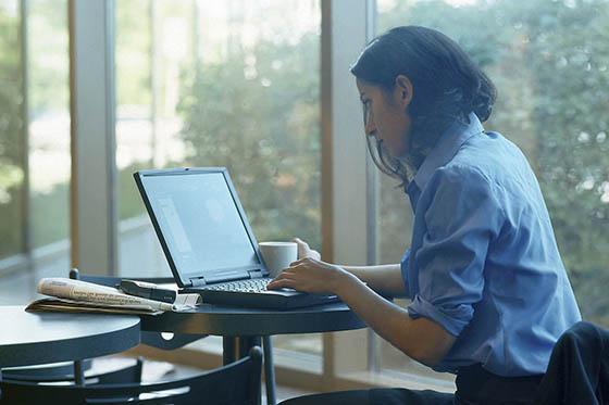 一个穿蓝色衬衫的女人在笔记本电脑上工作的照片