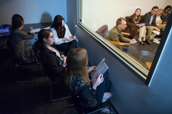 波胆网站心理学专业的学生坐在镜子后面观察治疗过程的照片. 