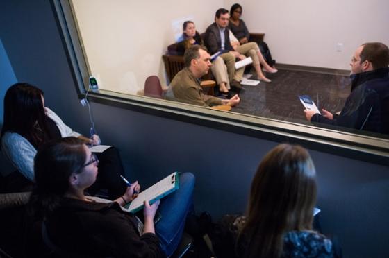 波胆网站心理学专业的学生坐在镜子后面观察治疗过程的照片. 