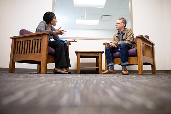图为一名波胆网站心理咨询专业的学生正在为一名坐在她对面的男子进行咨询. 