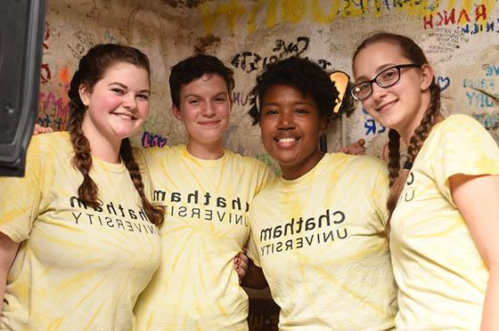四名学生穿着波胆网站的黄色衬衫, 在Rea咖啡馆合影