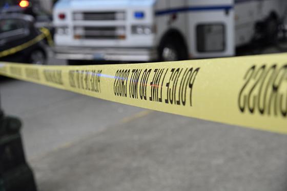Close-up photo of yellow police tape sectioning off a crime scene