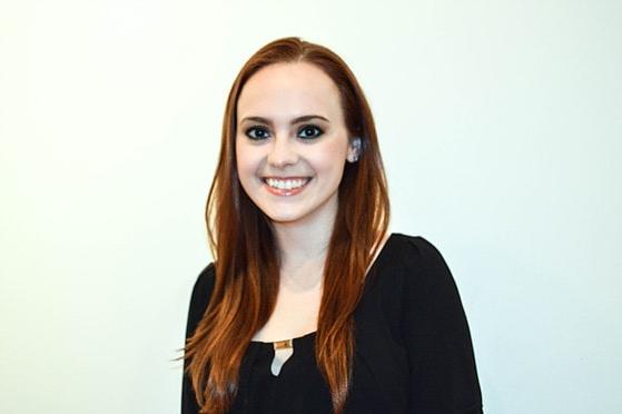 图为一名英国波胆网站的女学生站在白色背景前微笑