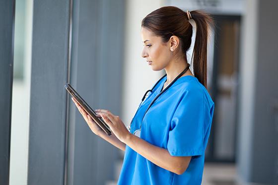 一个穿着蓝色手术服的护士看病历的照片