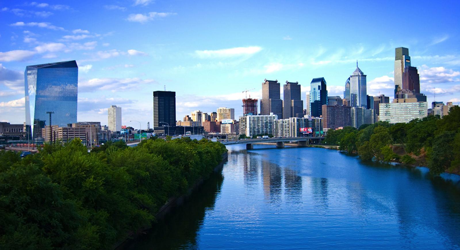 费城天际线的照片，有一条河和蓝天. 