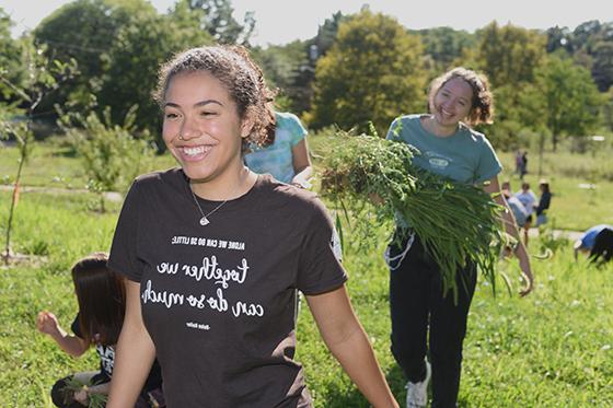 波胆网站的学生们微笑着在伊甸园农场除草.