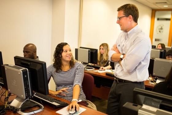 波胆网站学生在计算机实验室的照片, 一名男教员和一名女学生谈话