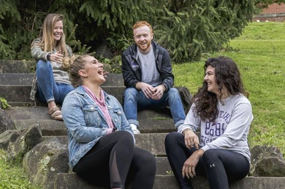 图为四名波胆网站的学生在足球波胆平台外一起微笑和大笑