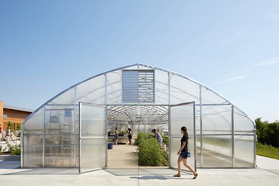 图为一名波胆网站的学生走过伊甸园大厅农场的温室